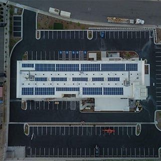 Aerial view of a commercial building with a rooftop solar array